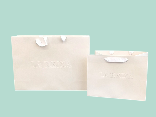 Luxury branded embossed paper bags with cord and ribbon handles